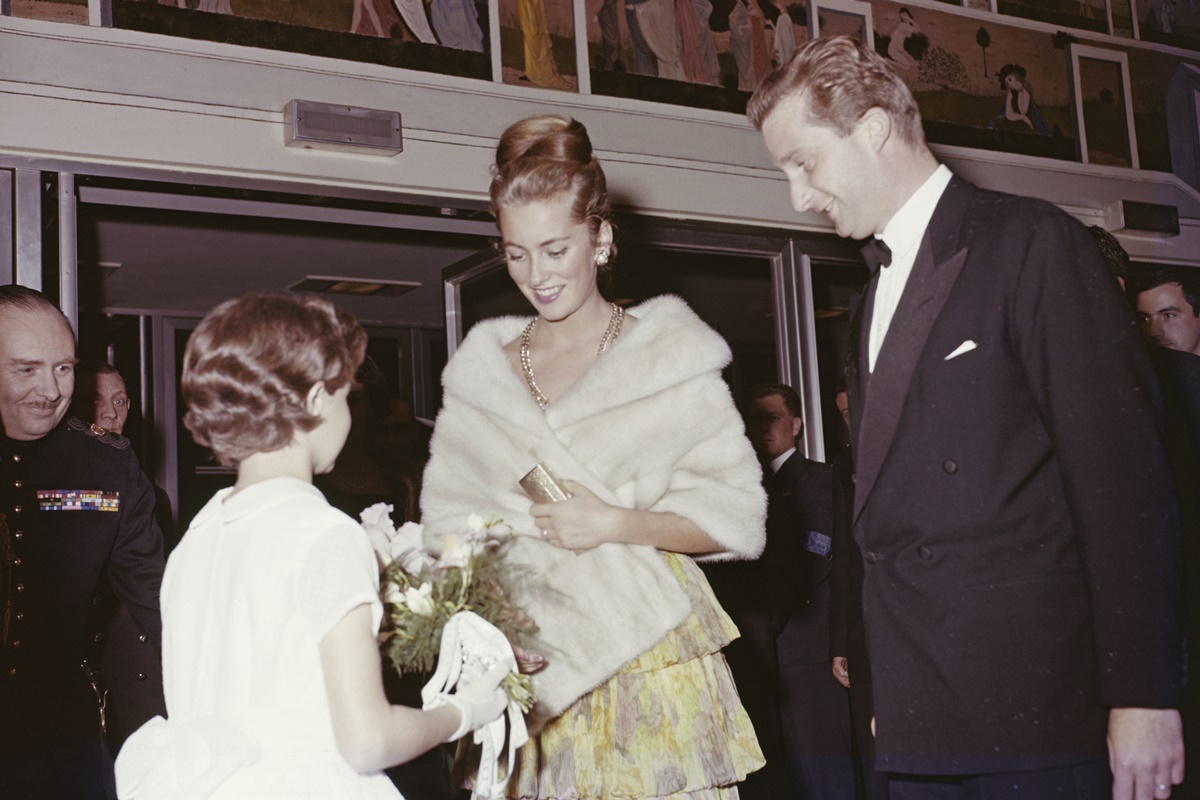  Então Princesa Paola de Liège (futura Rainha Paola da Bélgica) e o Príncipe Alberto (futuro Rei Alberto II) recebendo um buquê de flores de uma jovem