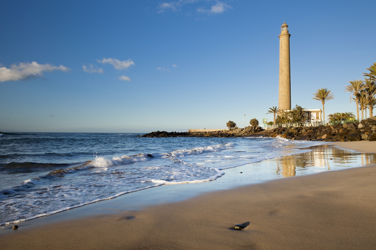 Foto colorida de praia e farol - Metrópoles