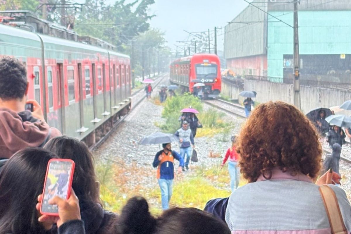 Passageiros caminham sobre trilhos após falha na Linha 12-Safira em SP