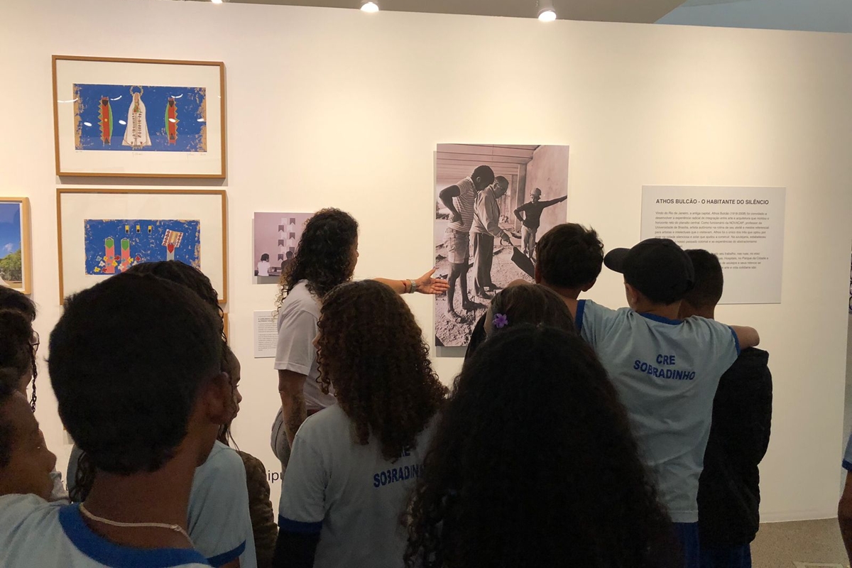 Foto colorida de alunos em visita guiada por exposição - Metrópoles