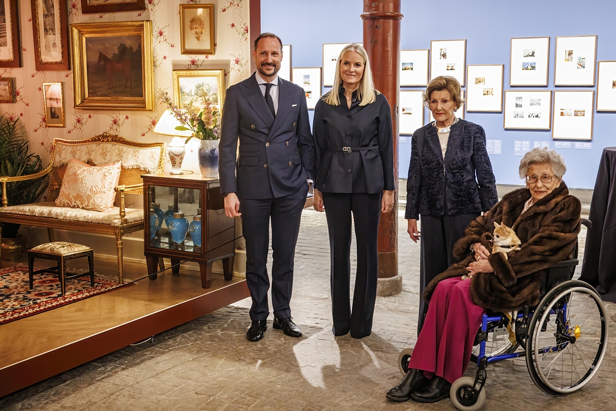 Foto colorida de homem e três mulheres, sendo uma em uma cadeira de rodas. Eles estão em uma sala com quadros - Metrópoles