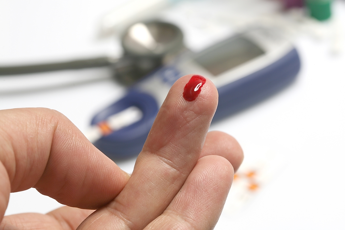 Foto colorida de dedo com sangue e dispositivo que mede glicose -Metrópoles